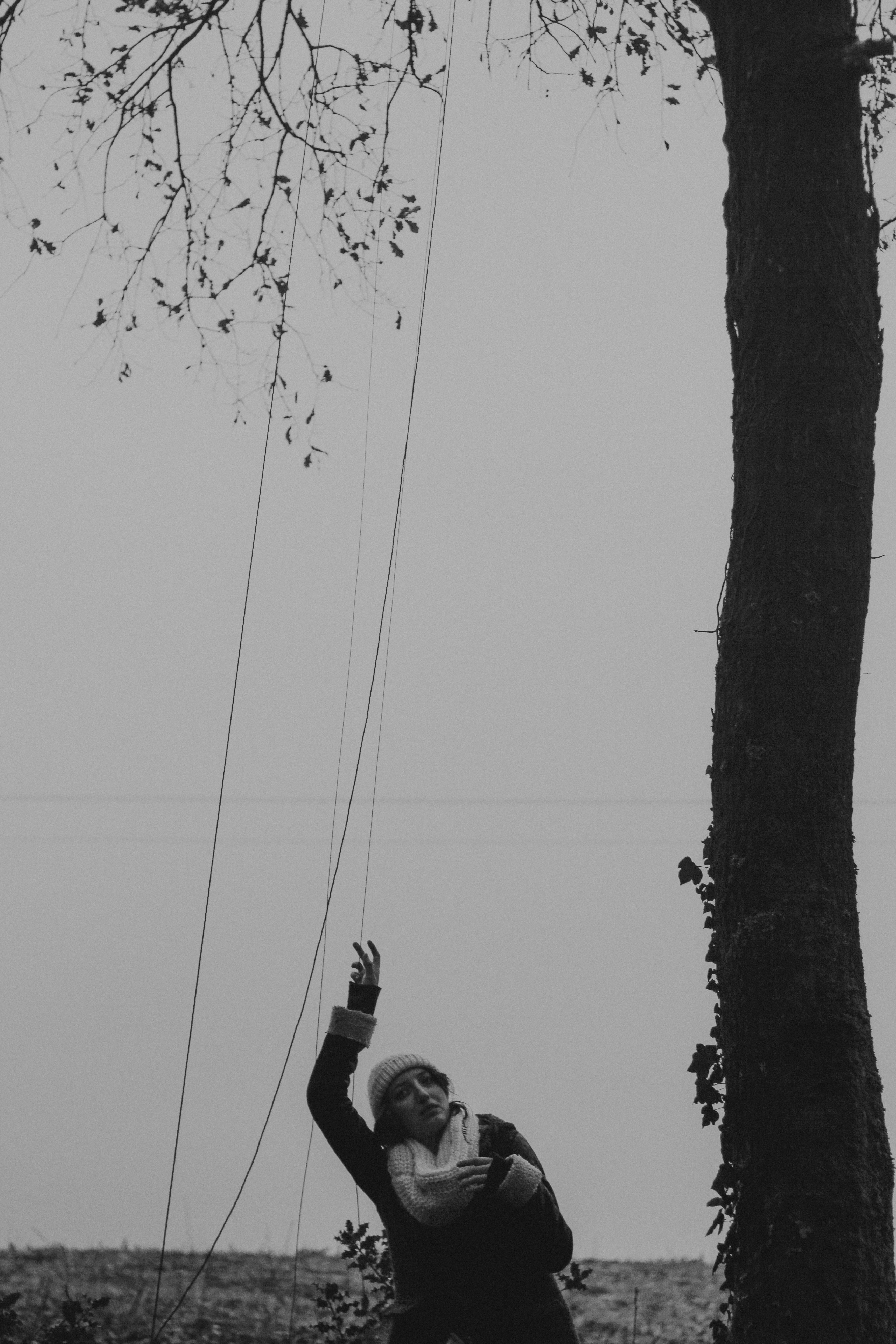 grayscale photo of woman raising hand